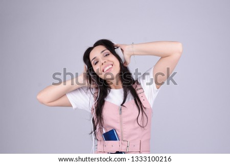 Gorgeous brunette lady in pink leather dress listen for her favourite music with white headphones. Audio book or internet radio podcast broadcast listen. enjoy and relax music