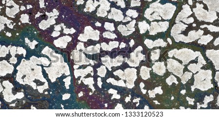 spots of white paint in the cracks on the asphalt. Texture. Abstract background.