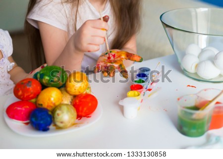 Beautiful little girl hands, painting Easter eggs color brush. Child portrait and kids hobby concept. Holiday interesting accessories. Amazing people picture.