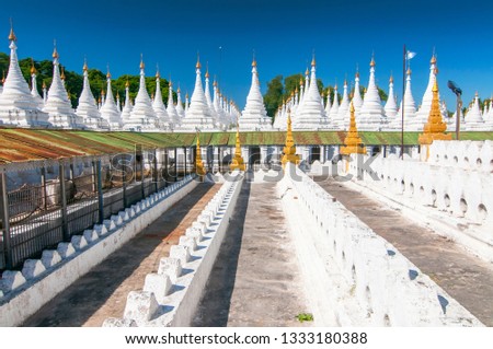 Golden Sandamuni Pagoda with row of white pagodas. Amazing architecture of Buddhist Temples at Mandalay, Myanmar.