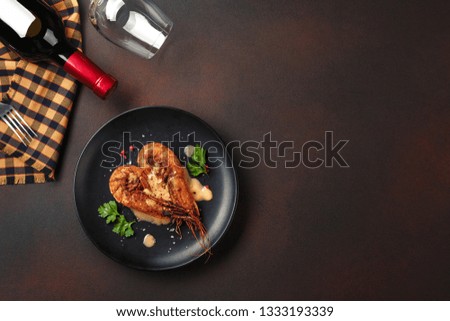 Romantic dinner with heart-shaped shrimps and wine on a brown background. Top view with copy space.
