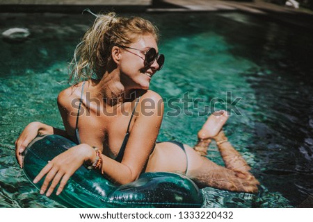 
female on vacation. Beautiful young woman swims in the pool on an inflatable circle