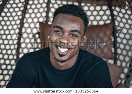 portrait of handsome African American man with earrings and black shirt. smiling  man on the photo. Phuket. Thailand. Summer vacation for Swaggy C.