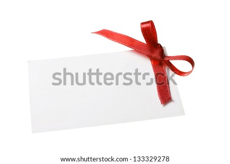 Blank gift tag tied with a bow of red satin ribbon. Isolated on white, with soft shadow