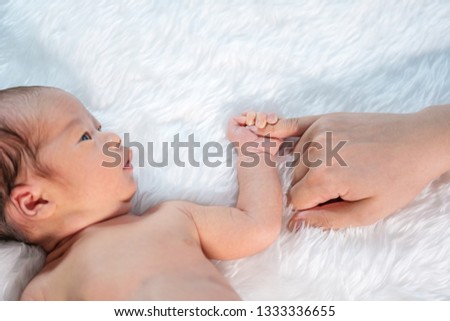 close up newborn baby boy holding little finger of mother's hand