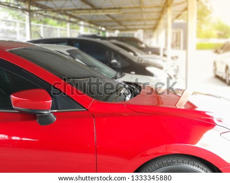 new red car in the parked with many cars on parking lot 

