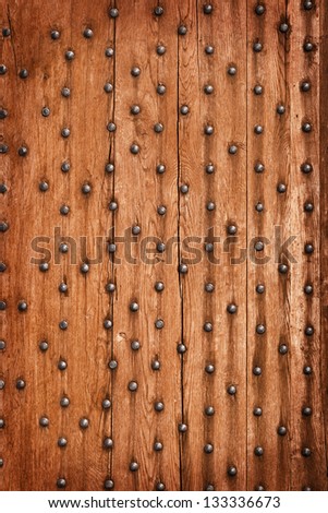 Vintage wooden background with metal rivets. The gate of the old castle.