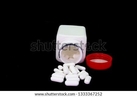 Tablets medicine pill are scattered on black background.