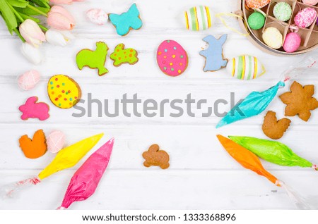 Child hands decorating honemade gingerbread with icing sugar using a pipping bag. Easter Treats. Handmade cookies, standing on the table. series of step by step photos. Royalty-Free Stock Photo #1333368896