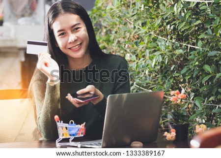 Asia woman holding credit card and using smartphone with happy.