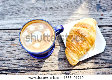 Refresh in the morning with coffee latte and croissant in sunlight on old wooden plank, exotic texture in the mood of breakfast top view in natural sunlight, isolated copy space, mood and tone picture