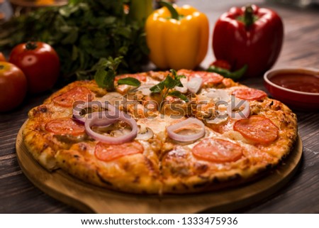 A well decorated pizza served on a wooden table and ready to eat.