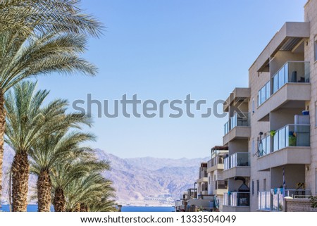 south city street symmetry photography with house buildings apartment and palm trees on soft blue sky background in summer season clear weather time, Eilat Israel 