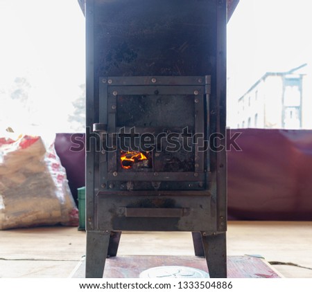 A black cast iron fire place with wood burning inside of it