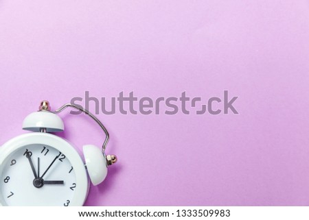Ringing twin bell vintage classic alarm clock Isolated on purple violet pastel colourful background. Rest hours time of life good morning night wake up awake concept. Flat lay top view copy space