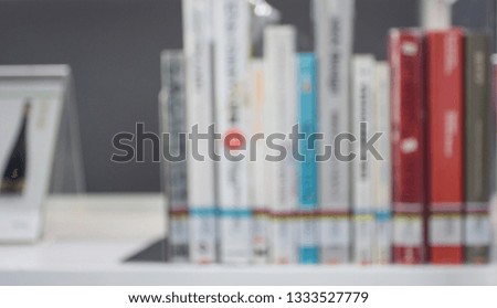 Blurred image cover of books, textbooks and magazines on bookshelves in public library for education concept