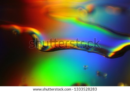 Water drops on mirror with light interference effect, color diffraction. Iridescent blurred holographic surface.