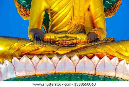 Closeup hand of gold buddha statue in the temple at night time