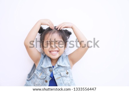 Asian child or kid girl lovely smiling and close eye make heart by arm and hand on top head or Sarang hae yo for love valentine or wedding with happy and enjoy on white background isolated with jeans