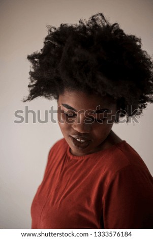 High ISO Color photos of a young African woman against a white wall with natural window light.