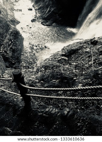 Black and white picture of the cord handrail and the rock stairway of the Kaminaridaki waterfall in the Nagano prefecture, Japan