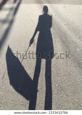 Picture of a shadow of a women holding down an umbrella on a sunny day in Kyoto, Japan