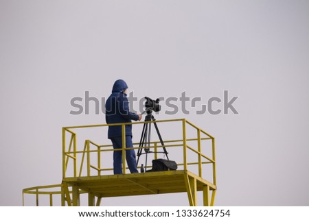 sports journalist makes a report on a filming tower