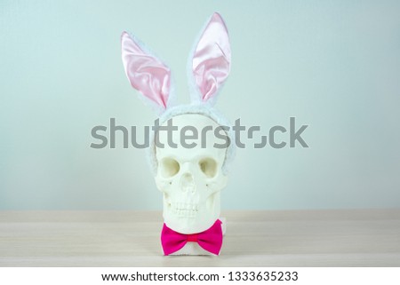 skull sculpture with bunny ear headbands and a pink bow tie. symbol Happy Easter holiday background concept. Free space for design
