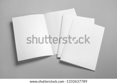 Blank half-folded booklet, postcard, flyer or brochure mockup template on gray background Royalty-Free Stock Photo #1333637789