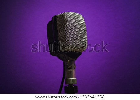 Vintage microphone, in a purple background. Retro professional equipment used on recording music.