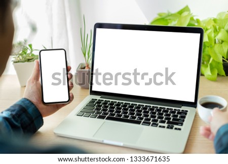 mockup image computer,cell phone and typing with blank screen for text,using laptop contact business searching information in workplace on desk in office.design creative work space on wooden desktop