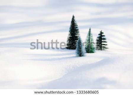 Small toy christmas trees on the snow