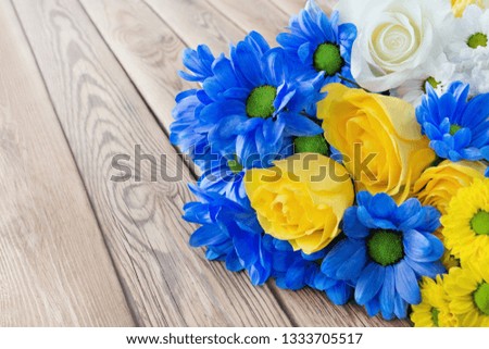 Chrysanthemums and roses against wooden background