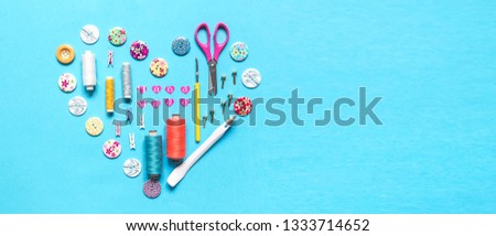 sewing thread set of sewing supplies in knolling pattern on light blue background flat lay top view, template mockup hand made long banner