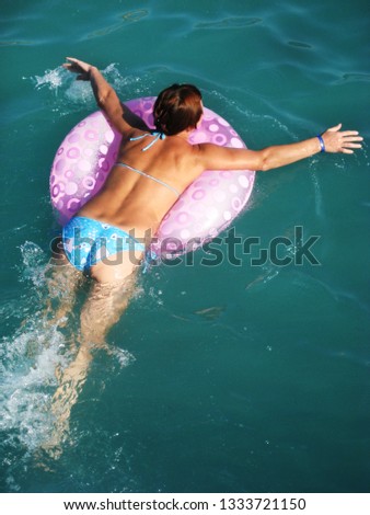 girl happily swimming in the sea on a circle