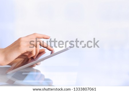 Female hand holding business digital tablet touching screen display by finger using computer device, woman working with modern pc pad, people and technology concept background, close up, copy space