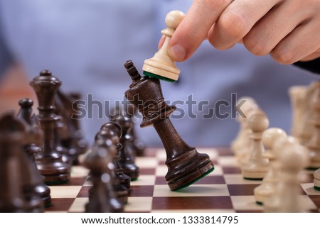 Chess Player Makes A Move To Defeat King Piece Royalty-Free Stock Photo #1333814795