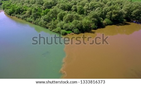 Two rivers of different colors of water merge into one large riv
