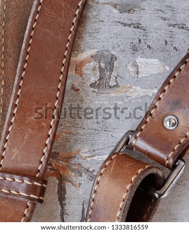 Leather belt with a buckle on a wooden board and space for text.