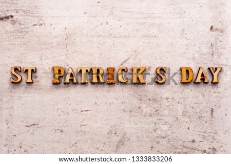 Inscription ST PATRICKS DAY in wooden letters on a light background.