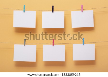 place for photo cards of pleasant  moments, empty blanks attached to a linen rope in two rows withstationery clips on a colored background,template for reminder notes