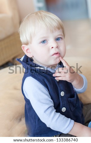 Little toddler boy eating fresh blueberry indoor
