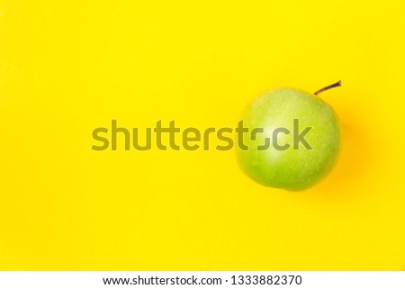 Fresh and green apples on a yellow background. There is a place for text.