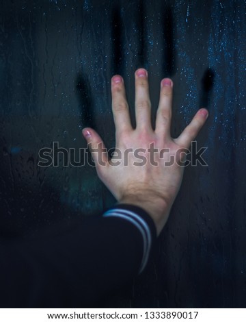 Eerie photo of hand clawing at misty window