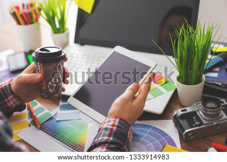 Young Handsome Graphic designer using graphics tablet to do his work at desk