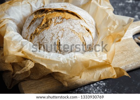 white bread on wooden board and in black background. Fresh hot bread. Close up