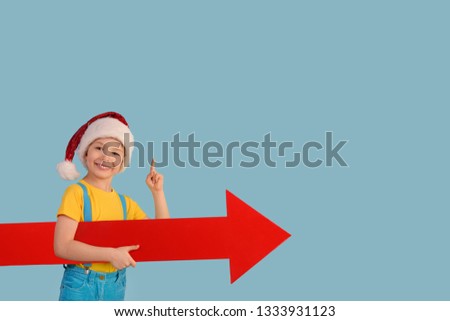 Little boy doing attention gesture and holding a progress arrow.