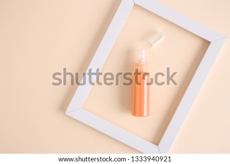 Perfume bottle in white frame on yellow pastel background minimal creative concept. Space for copy.