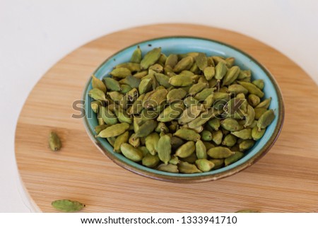 cardamom seeds in a bowl on dark background, close up, selective focus