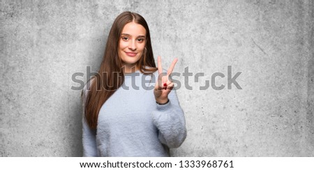 Young caucasian woman showing number two